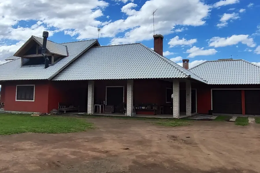 Casa vermelha com o telhado claro e limpo depois do serviço da Machado, sob céu azul